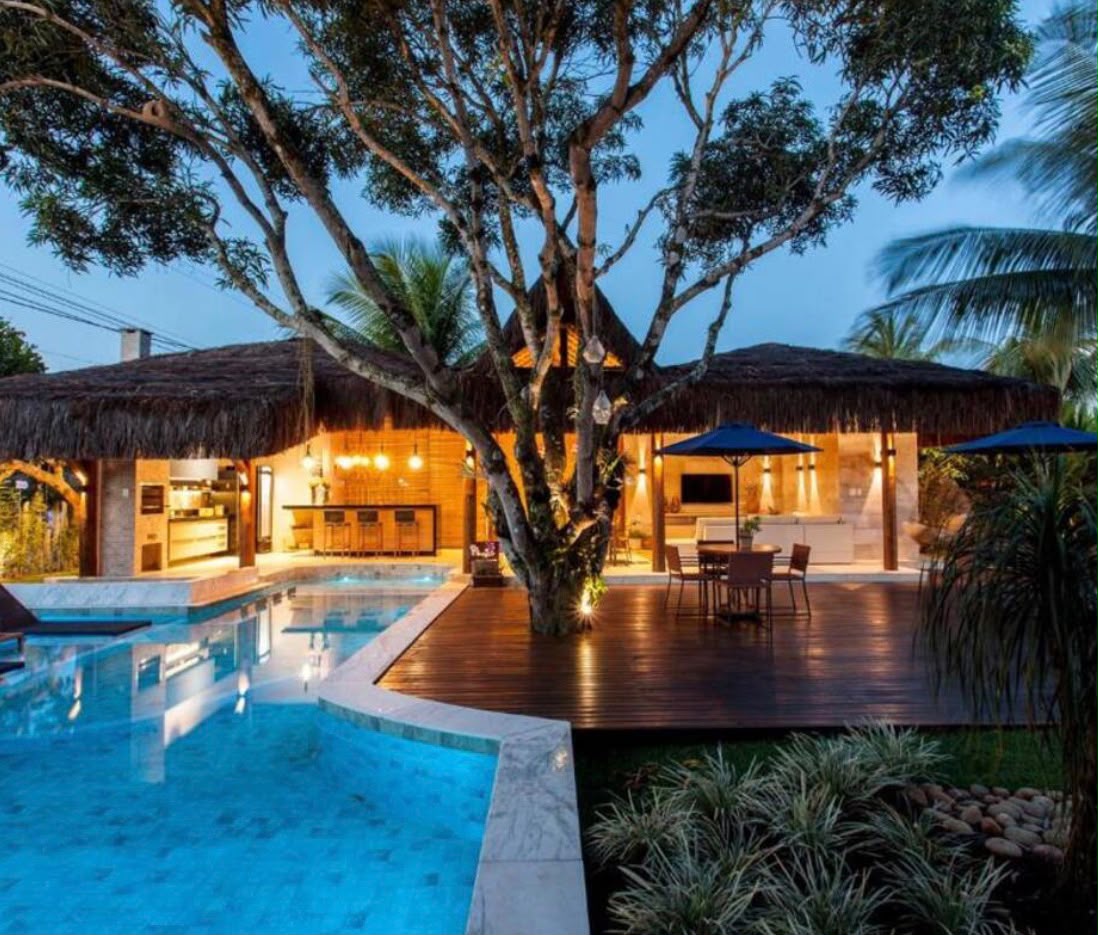 Casa de praia com piscina e deck de madeira ao entardecer antes do tratamento